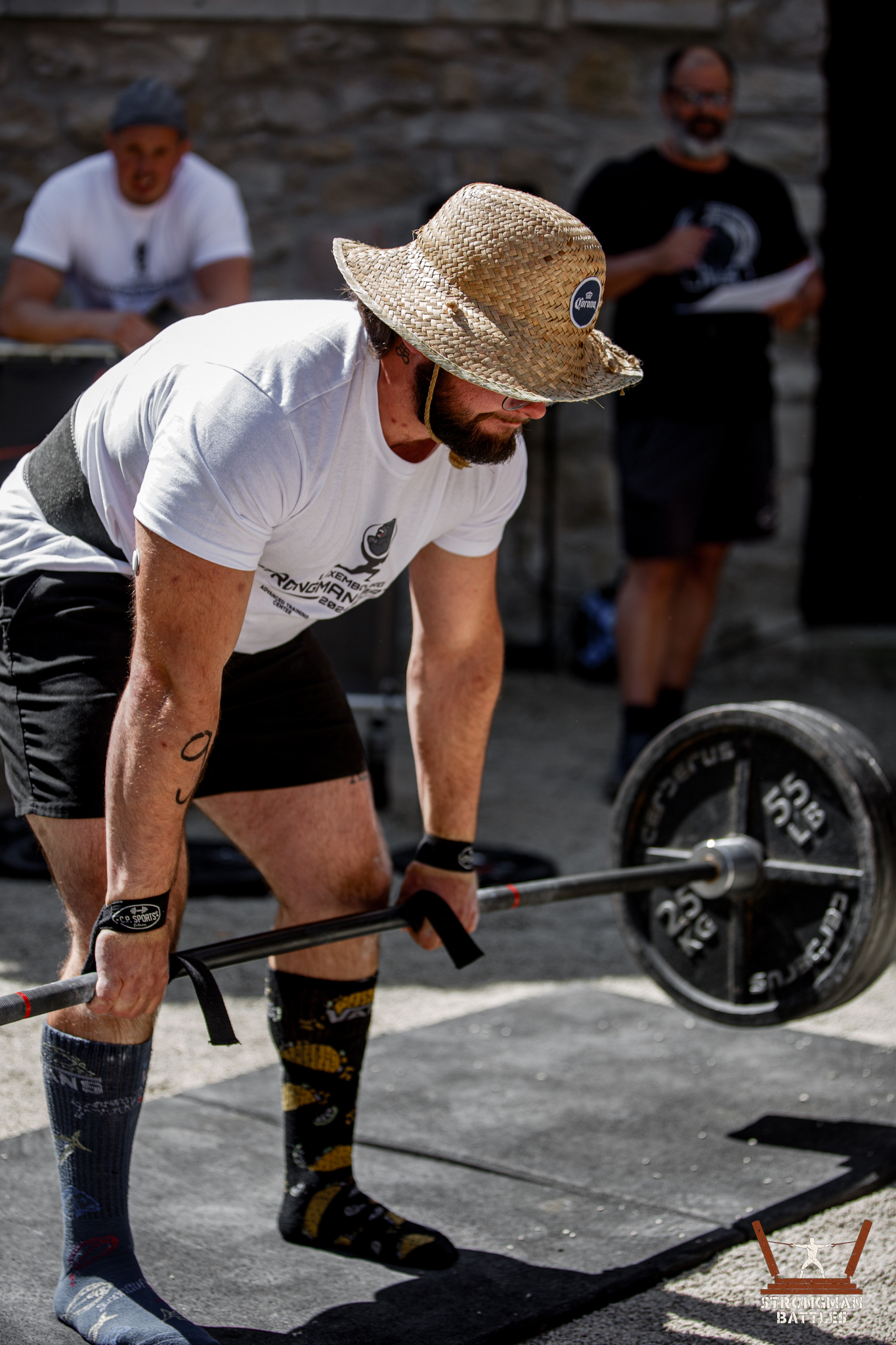 Participant deadlifting an axle at an outdoor strength event